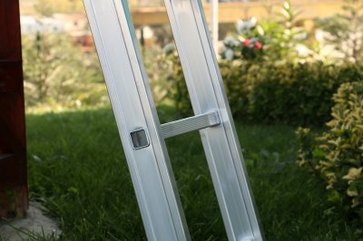 Miljöbild på en grå stege utomhus med buskar i bakgrunden