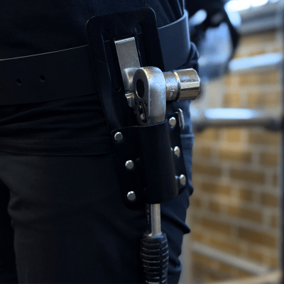 Holder til vaterpas/skraldenøgle med ProClip monteret i bælte, hvor skraldenøglen sidder sikkert og let tilgængeligt under arbej