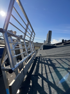 Närbild med blå himmel på SGS fallskyddsräcke längs med rännan