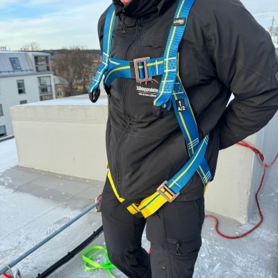 gul och blå fallskyddssele på frostigt tak