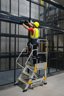 trappa uppställd i idustrill mijö med person i varselkläder